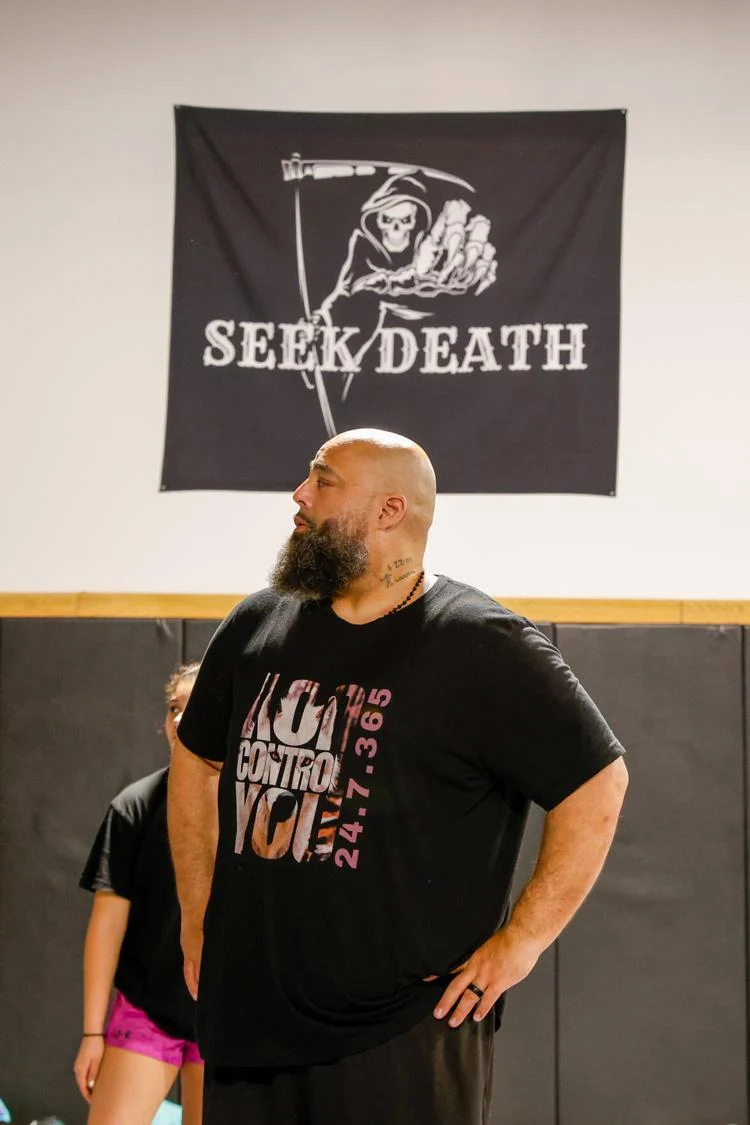 Mark “ShaH” Evans standing beneath the Seek Death banner.